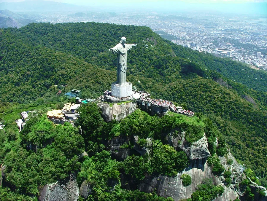 Aerial view of Christ the Redeemer atop Corcovado, surrounded by the Tijuca forest, with the city of Rio de Janeiro behind